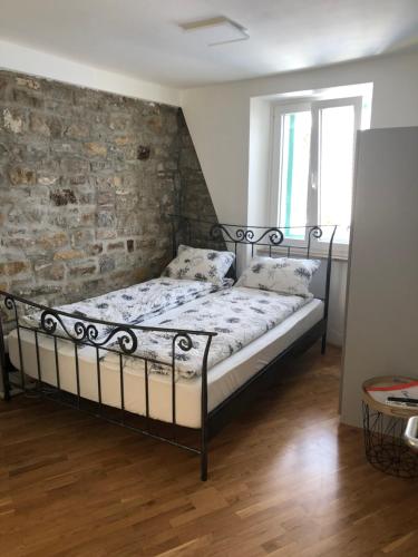 uma cama num quarto com uma parede de tijolos em Casa David em Piran