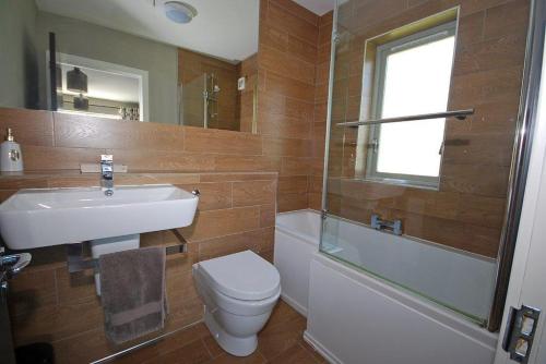 a bathroom with a sink and a toilet and a shower at Amber Cottage - Luxury Cottage, Hot Tub, Sea Views and Log Burner in Saundersfoot