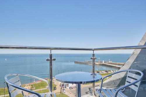 a balcony with a table and chairs and the ocean at Host & Stay - Pier View Penthouse in Whitby