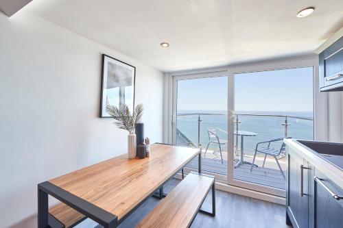 a dining room with a table and a view of the ocean at Host & Stay - Pier View Penthouse in Whitby