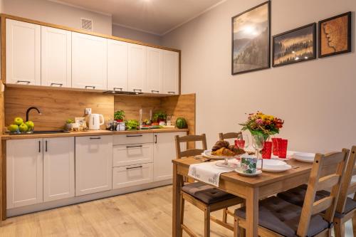 a kitchen and dining room with a table and chairs at Apartament Słoneczny Poranek in Ustrzyki Dolne