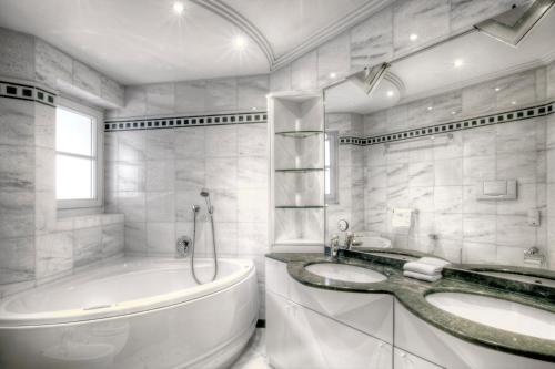 biała łazienka z 2 umywalkami i wanną w obiekcie Alexander Mountain-Lodge w mieście San Vigilio di Marebbe