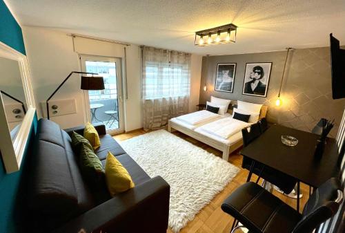 un soggiorno con divano e letto di Design Apartment Vendome a Friburgo in Brisgovia