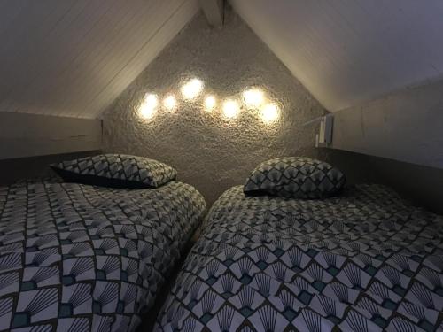 two beds sitting next to each other in a room at Joli petit appartement au calme, refait à neuf, avec linge de maison fourni in Cauterets