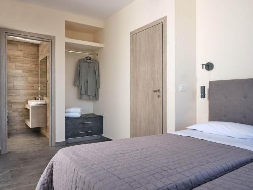 a bedroom with a bed and a bathroom with a sink at Errikos Family Villa - Serene Environment and Private Pool, by ZanteWize in Ayios Kirikos