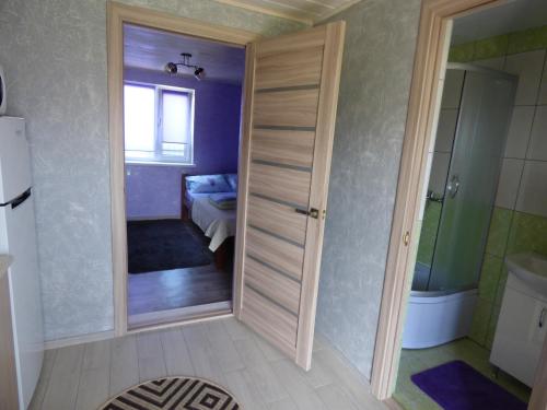 een badkamer met een deur naar een slaapkamer bij Приватна Садиба "У Оксани" in Pulʼmo