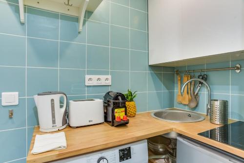 une cuisine avec des murs en carrelage bleu et un comptoir. dans l'établissement Beautiful Duplex Apt - 5 mins to Grand Rex, à Paris