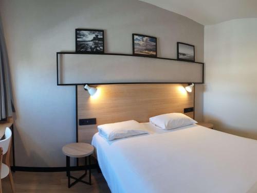 a bedroom with a large white bed with two pillows at ibis Ciboure Saint-Jean-de-Luz in Ciboure