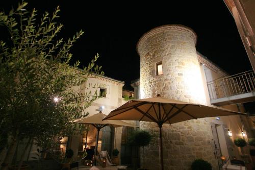 two umbrellas in front of a building at night at Hôtel Étoiles d'Orion in Marsolan