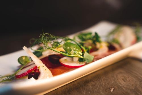 a plate of food with vegetables on a table at Qudos in Salisbury