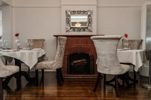 a dining room with two tables and a fireplace at The View Boutique Hotel & Spa in Amanzimtoti
