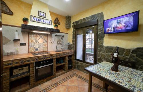 a kitchen with a tv on the wall at APARTAMENTO LA VEGUILLA in Alhama de Aragón