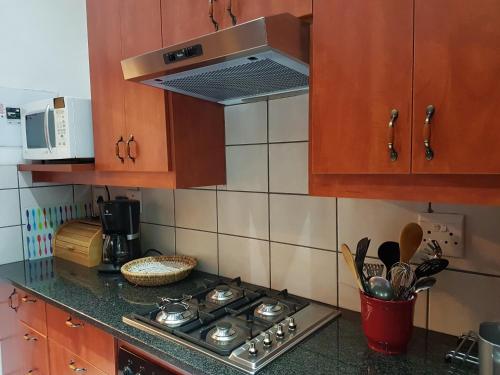 a kitchen with a stove and a microwave at House Rossini in Pretoria