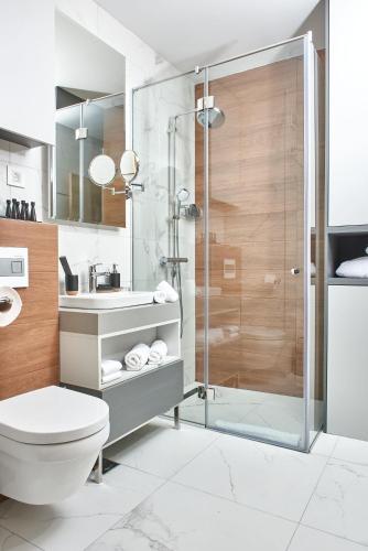 a bathroom with a shower and a toilet and a sink at Zlatibor Residence & Suites in Zlatibor