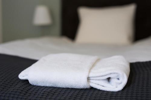 a stack of white towels sitting on a bed at Continental Apartment Hotel Sollentuna in Sollentuna