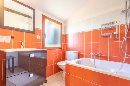 La salle de bains orange est pourvue d'une baignoire et de toilettes. dans l'établissement Vermeille, à Céret