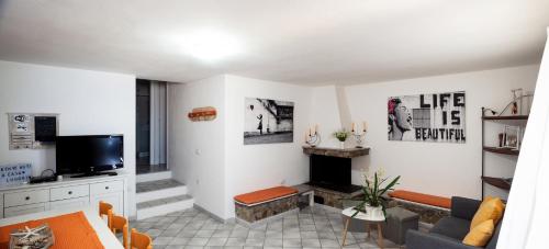 sala de estar con chimenea y TV en Casa Lugori en Torre Dei Corsari