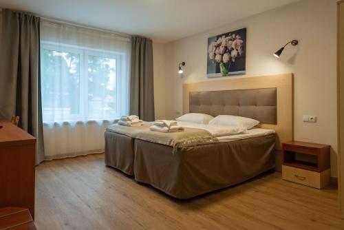 a bedroom with a large bed with towels on it at Senasis Nemunas in Druskininkai