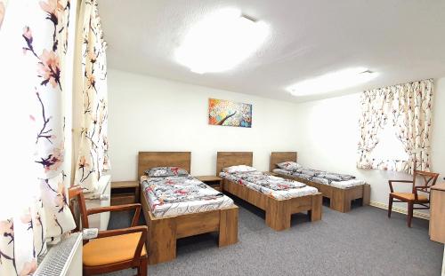 una habitación de hospital con 3 camas y sillas en Zur Krone - Ferienhaus 2, en Widdershausen