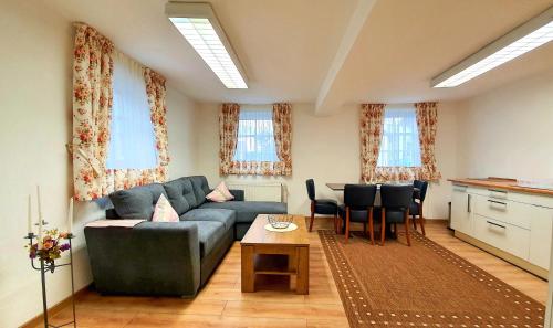 uma sala de estar com um sofá e uma mesa em Zur Krone - Ferienhaus 2 em Widdershausen