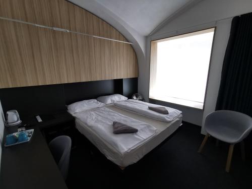 um pequeno quarto com uma cama e uma janela em Cha Cha Rooms em Ljubljana