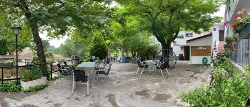 a patio with tables and chairs and aokedoked wheel at Pensión Pradera in Mesones