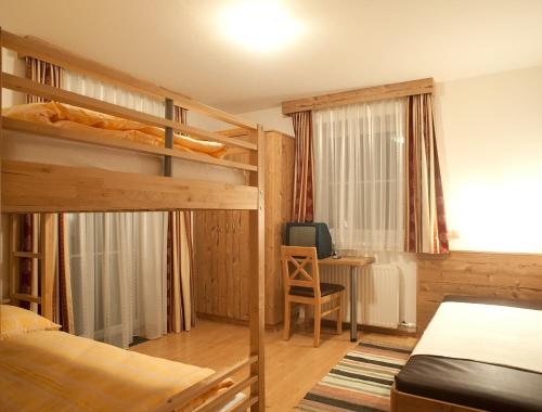 1 Schlafzimmer mit 2 Etagenbetten und einem Schreibtisch in der Unterkunft Ferienhaus Deutschmann in St. Johann im Pongau