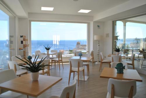 a restaurant with tables and chairs and a large window at Est hotel in Santa Cesarea Terme