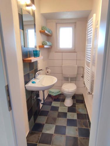 a bathroom with a toilet and a sink at Webers Ferienwohnungen in Hilders