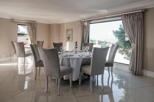 a dining room with a table and chairs and a window at The View Boutique Hotel & Spa in Amanzimtoti