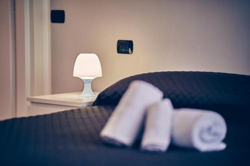 a bedroom with a bed with a lamp and towels at Travelershome 7Metri GuestHouse in Ciampino