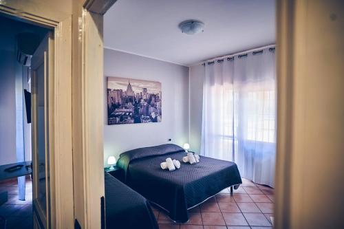 a bedroom with a bed with two teddy bears on it at Travelershome 7Metri GuestHouse in Ciampino