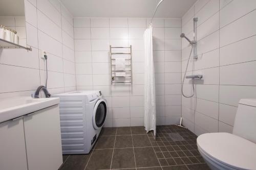 a bathroom with a washing machine and a toilet at Continental Apartment Hotel Sollentuna in Sollentuna