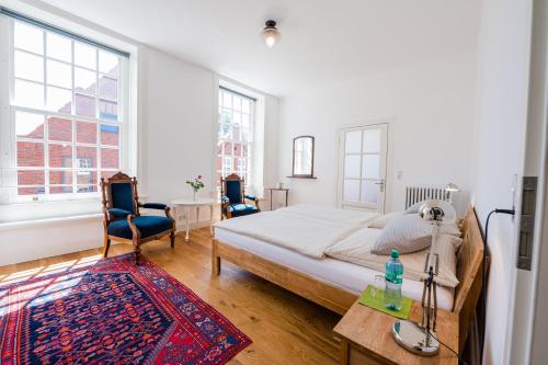 1 dormitorio con 1 cama, 2 sillas y mesa en Haus Äskulap - Altstadt, Hafen, Gallimarkt en Leer