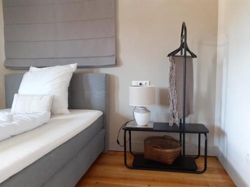 a bedroom with a bed and a table with a lamp at Tauber Lodge in Creglingen