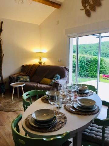 une salle à manger avec une table avec des assiettes et des verres à vin dans l'établissement Cottage Combet Gîte Climatisé avec Jacuzzi, à Marsanne