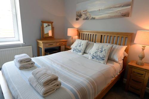 a bedroom with a bed with towels on it at Mermaid Apartment - Sea Front Apartment with Views in Saundersfoot