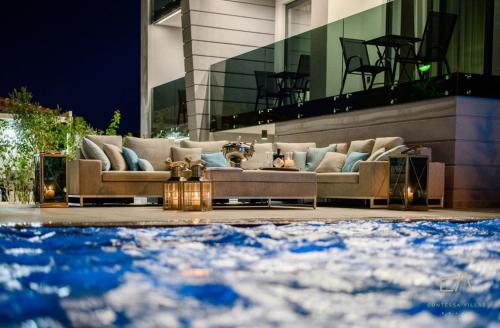a living room with couches in front of a building at Deluxe Villa Curiera in Malinska