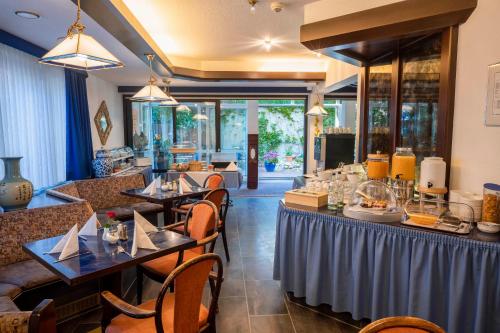 un ristorante con tavoli e sedie e un bar di Hotel Astoria am Urachplatz a Stoccarda