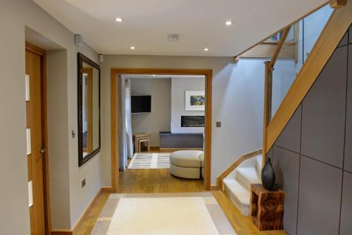 a hallway with a staircase and a living room at Priory Cottage - Luxury Cottage, Near to Beach in Saundersfoot