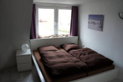 1 cama en la esquina de una habitación con ventana en Sophia Hameln - maritim wohnen im Weserbergland, en Hessisch Oldendorf