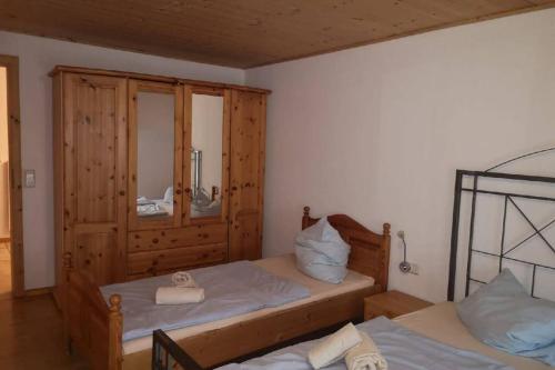 een slaapkamer met 2 bedden en een spiegel bij Andermichlhof (3)Ferienwohnung Groß Landsberger Strasse 8 in Geltendorf