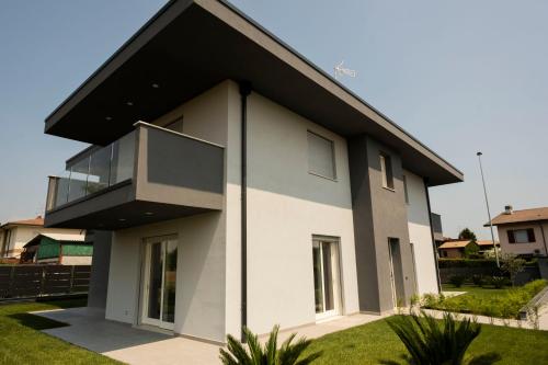 Biały dom z czarnym dachem w obiekcie Marali Lake Apartments w mieście Desenzano del Garda