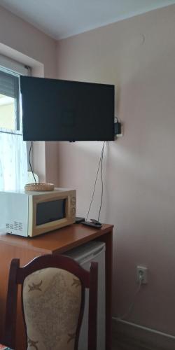 kuchenka mikrofalowa na stole z krzesłem w obiekcie Liza Apartman w mieście Gyula
