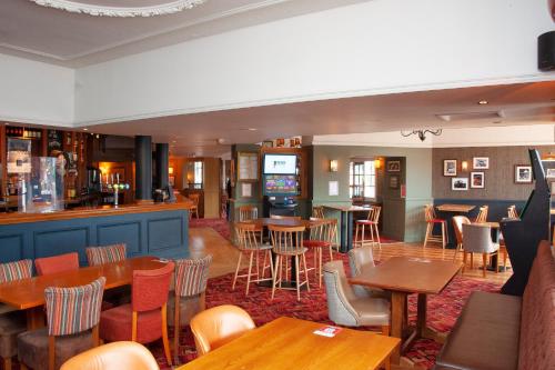 a restaurant with tables and chairs and a bar at Shah of Persia, Poole by Marston's Inns in Poole