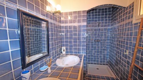 サント・マキシムにあるMazets du Soleilの青いタイル張りのバスルーム(トイレ、シンク付)