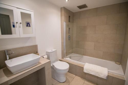 Un baño con inodoro, bañera y lavabo. en The Dairy - Luxury Cottage, Hot Tub and Summer House, Countryside Views, Pet Friendly, en Ludchurch