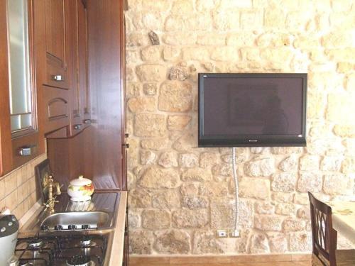 a stone wall with a television on a wall at Anticu Dammusu in Scicli