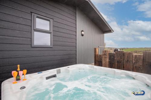 a jacuzzi tub sitting outside of a house at Valley View Lodge - Luxury Lodge, Hot Tub, Close to Beach in Penally