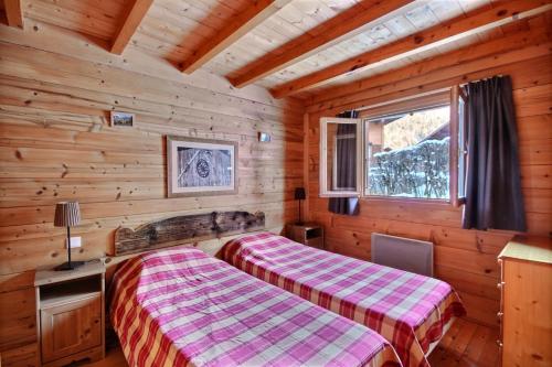 a bedroom with two beds in a log cabin at Appartement à 600m des remontées mécaniques, centre Morzine, chalet les Joux in Morzine